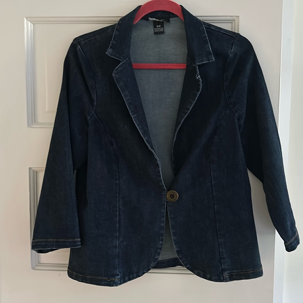 Cropped denim jacket with single button closure and darts in the back.
